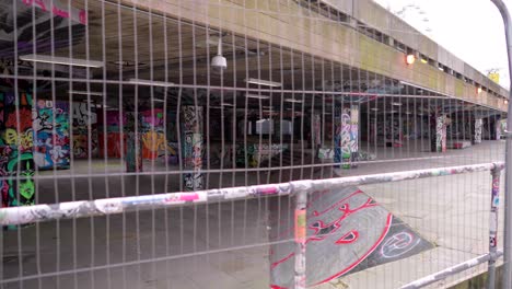 closed and empty skatepark in london during covid-19 coronavirus pandemic, underground and street art, graffiti on the walls