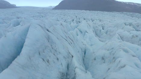 toma aérea cinematográfica baja sobre grietas y crestas en un gran glaciar