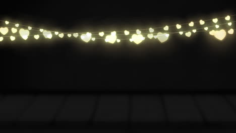 animation of yellow heart shaped glowing fairy lights hanging against copy space on black background