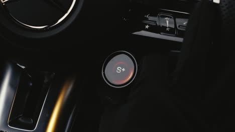 person use fingers turn round knob on steering wheel to change driving mode