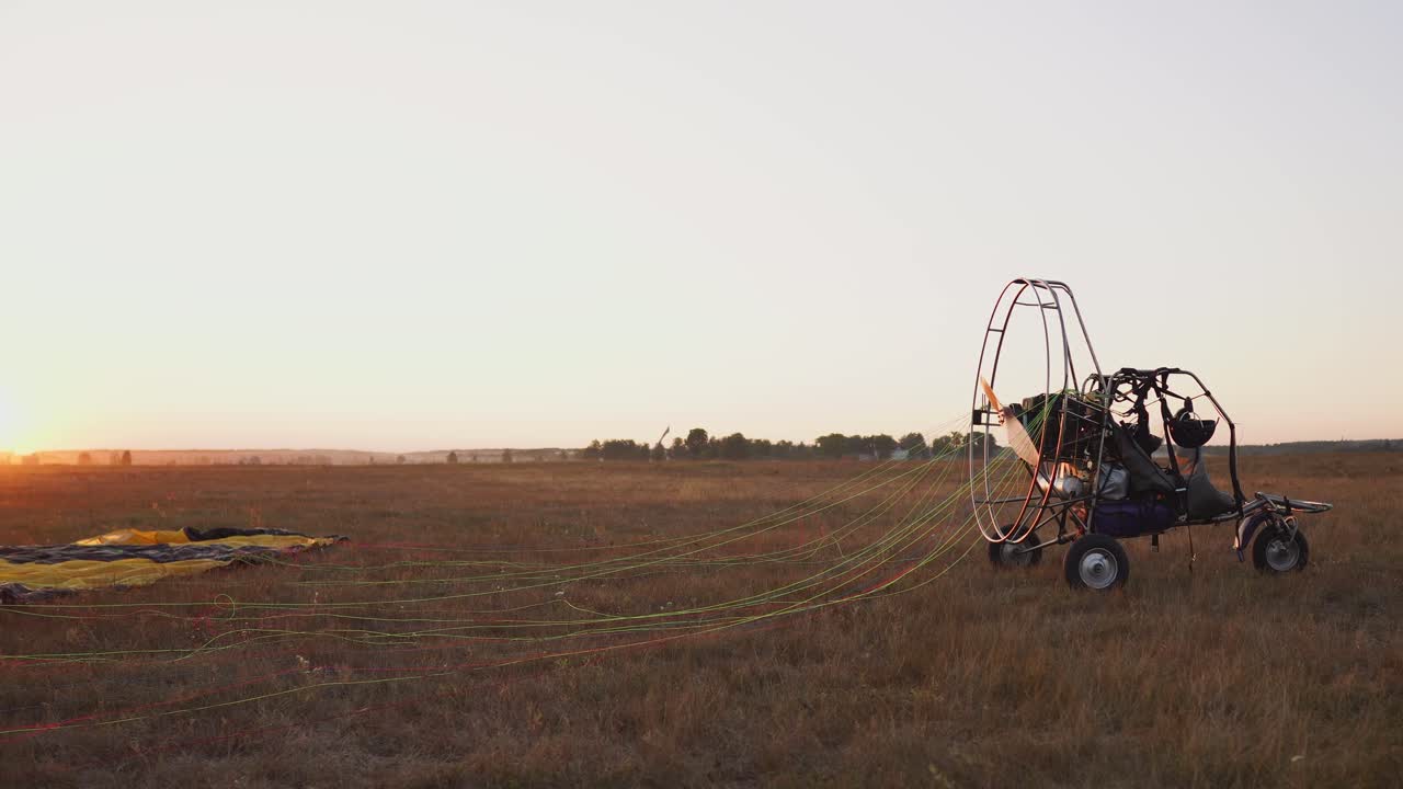 모터 패러글라이더는 따뜻한  ⁇ 빛에서 해가 지는 것에 맞서 하늘을 날아갈 준비가되어 있습니다.