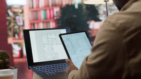 empresario que planea trasladar una oficina evaluando los planos arquitectónicos