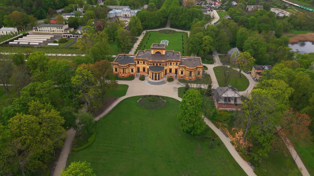 A stunning aerial view of the historic Trakų Vokė Manor surrounded by lush greenery in Trakai Lithuania cinematic quality stunning visuals rich detail, orbit shot