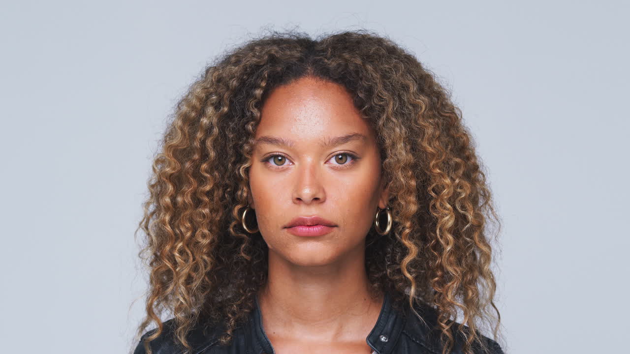 cabeza y hombros toma de estudio de una mujer mirando a la cámara con una expresión seria en cámara lenta