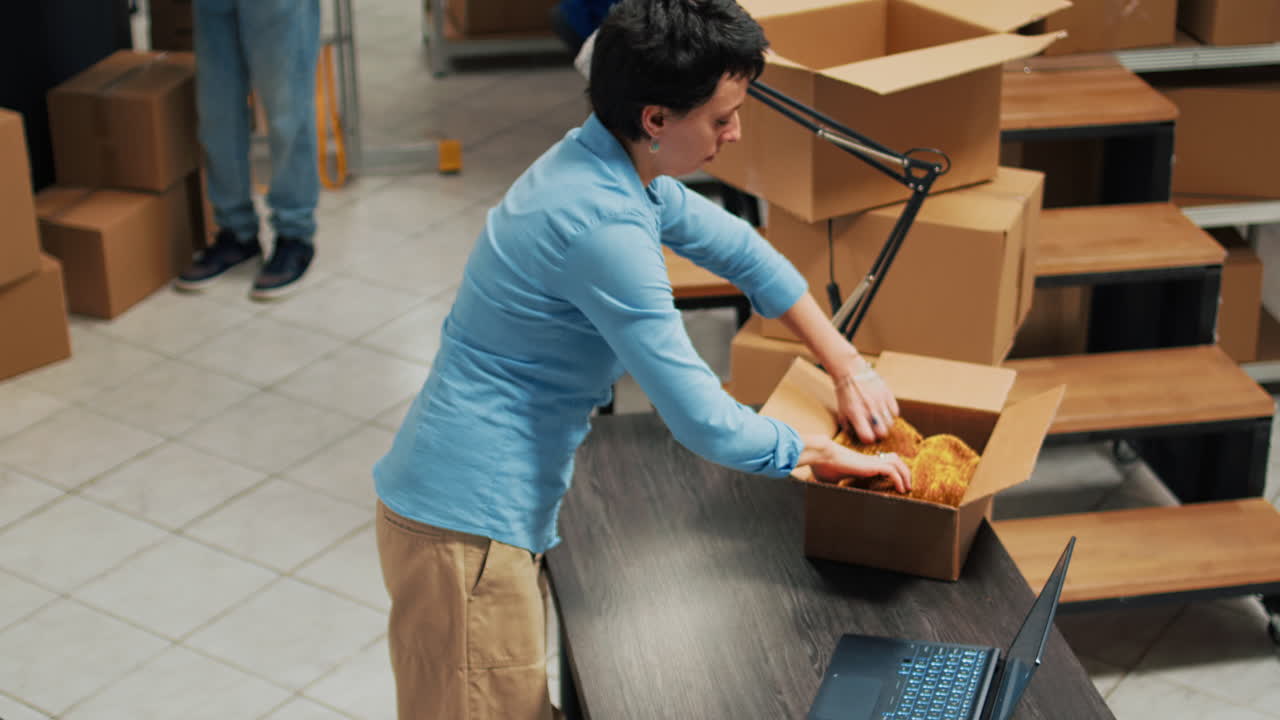 Woman packaging products in warehouse for online order fulfillment