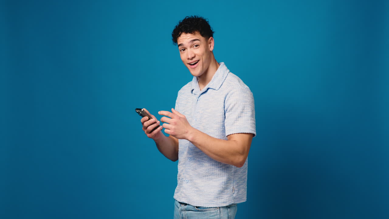 Man pointing at phone against blue background