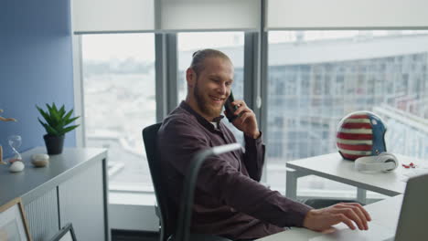 Laughing-student-speaking-smartphone-indoors-closeup.-Man-talking-emotionally