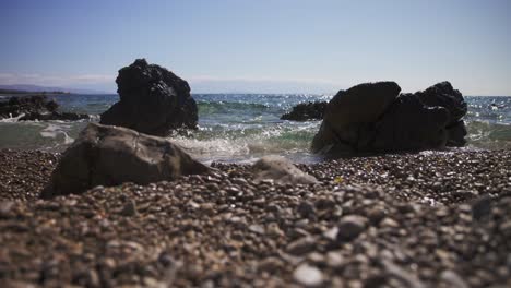 the waves hit the rocks on the pebble beach