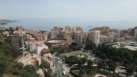 wide drone shot of coastal district and colosseum in malaga, spain