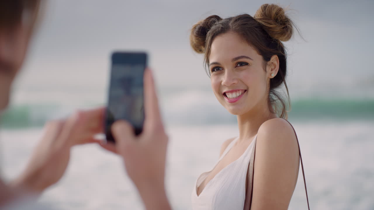 in primo piano una bella giovane donna che posa per una foto di coppia che scatta foto usando la fotocamera dello smartphone godendosi le vacanze estive viaggiando sulla spiaggia condividendo la connessione