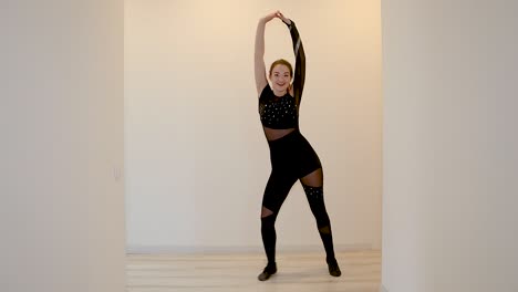 female dance performer dancing alone inside an apartment in slow motion wearing a black outfit