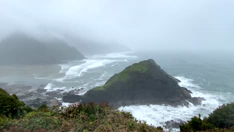 rugged oregon coastline, overcast and wild cape cove bay, handheld