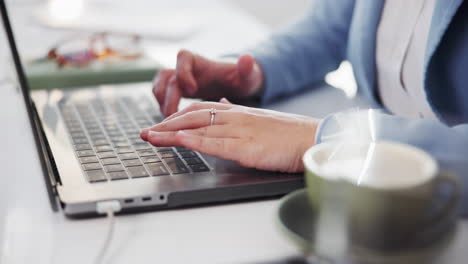 typing on laptop with coffee