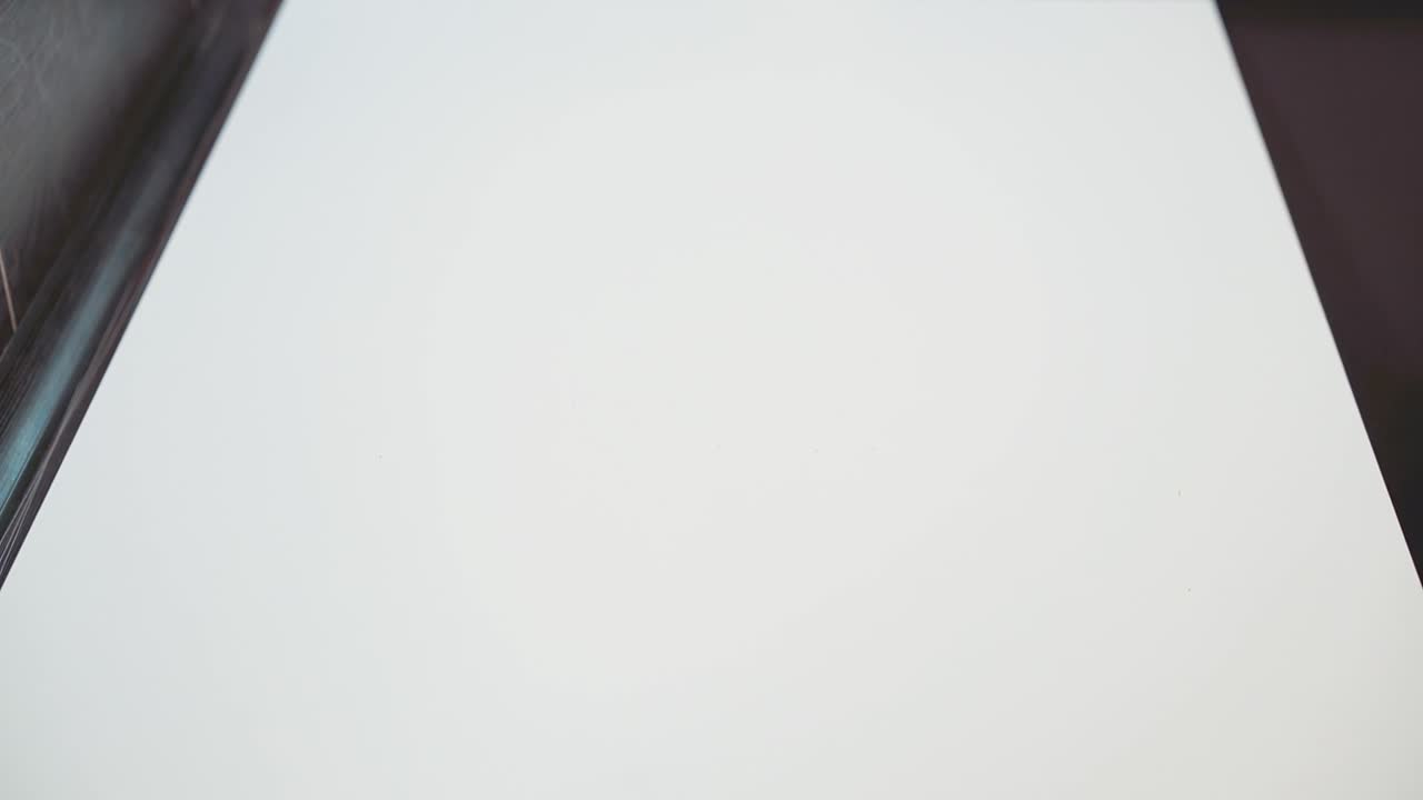 Un artigiano del mobile mostra un disegno sul tavolo. Primo piano.