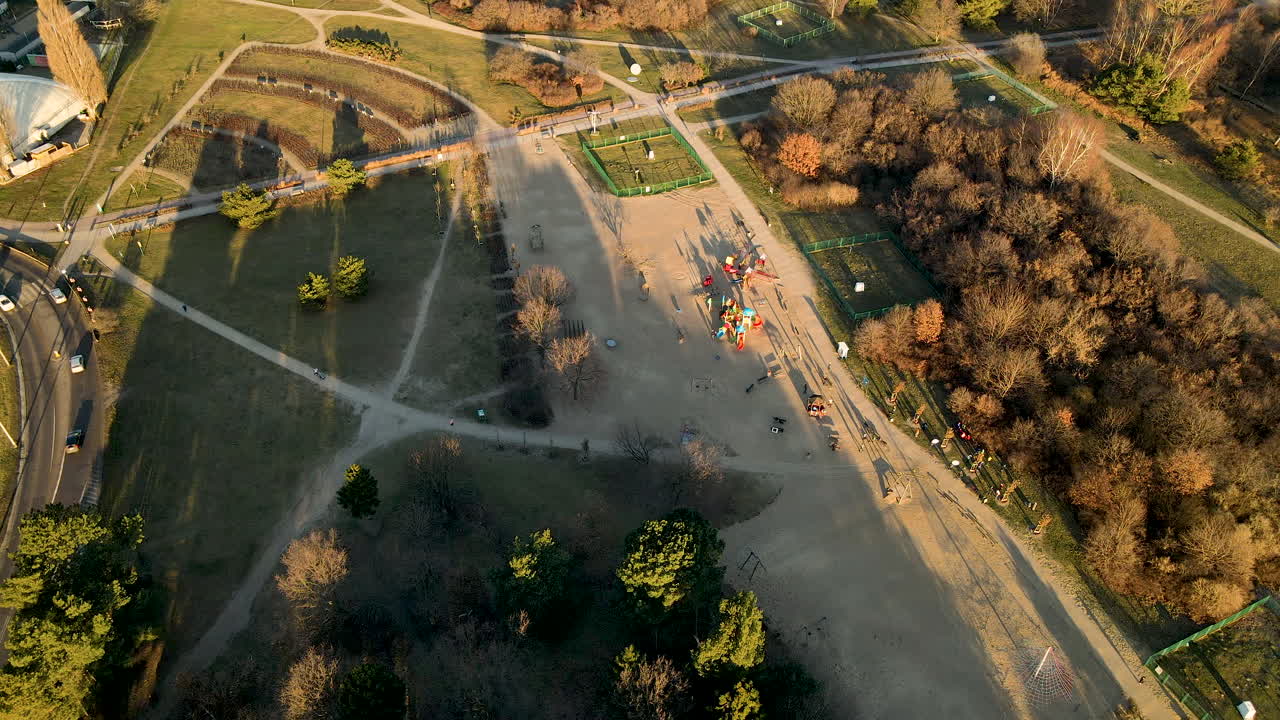 Children playing at public playground at sunset in Ronald Reagan Park, Gdansk, Poland - aerial top view