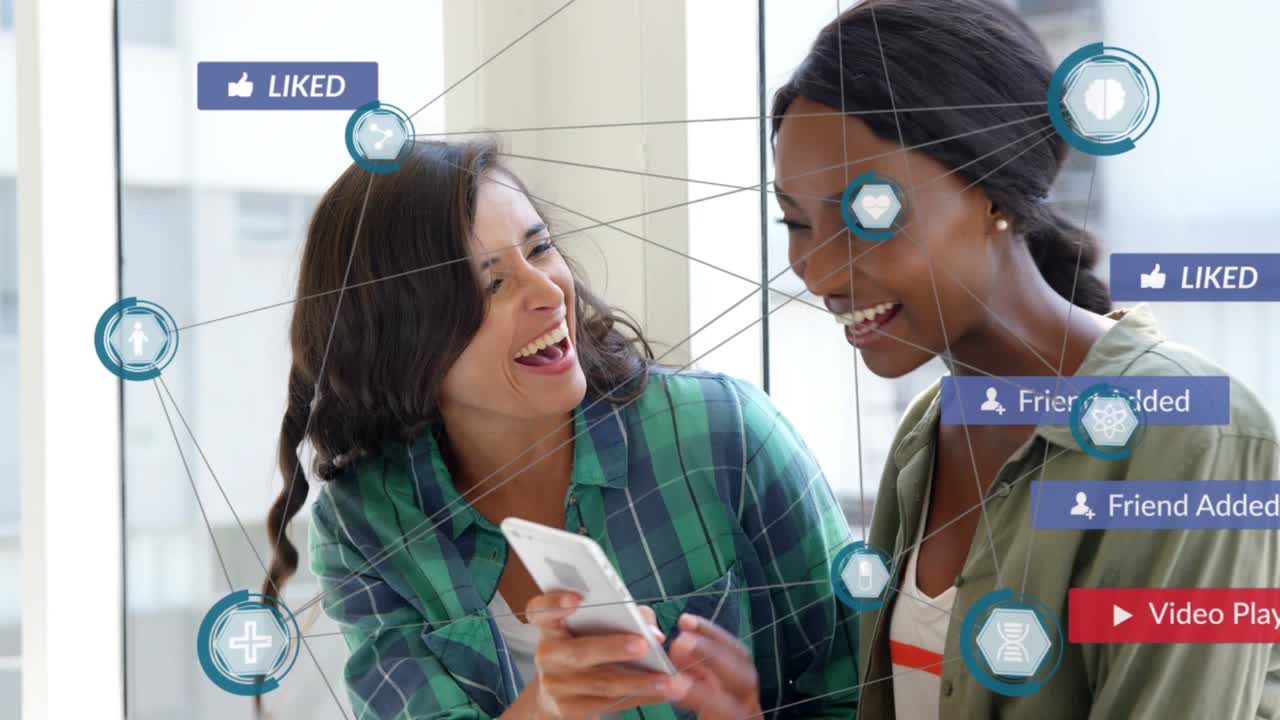 Animation of multiple social media icons against two diverse women taking a selfie at office