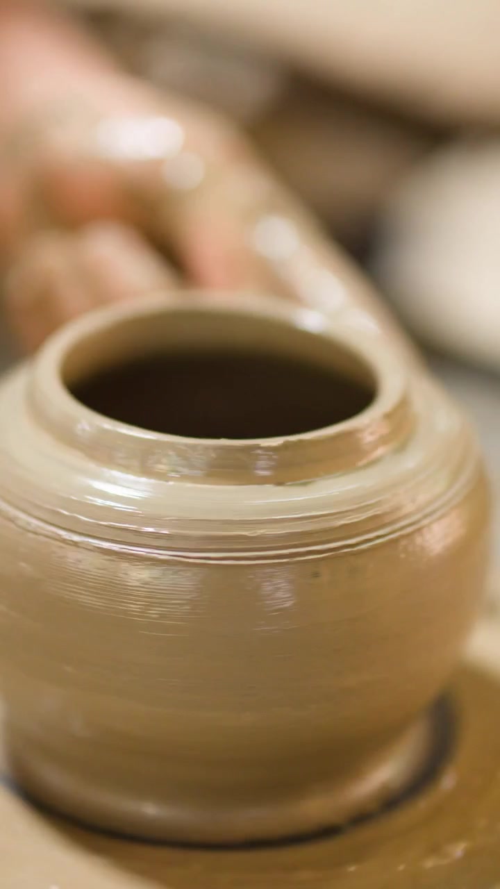 Primo piano delle mani di un vasaio che modellano un vaso d'argilla al tornio a Nonthaburi, Thailandia