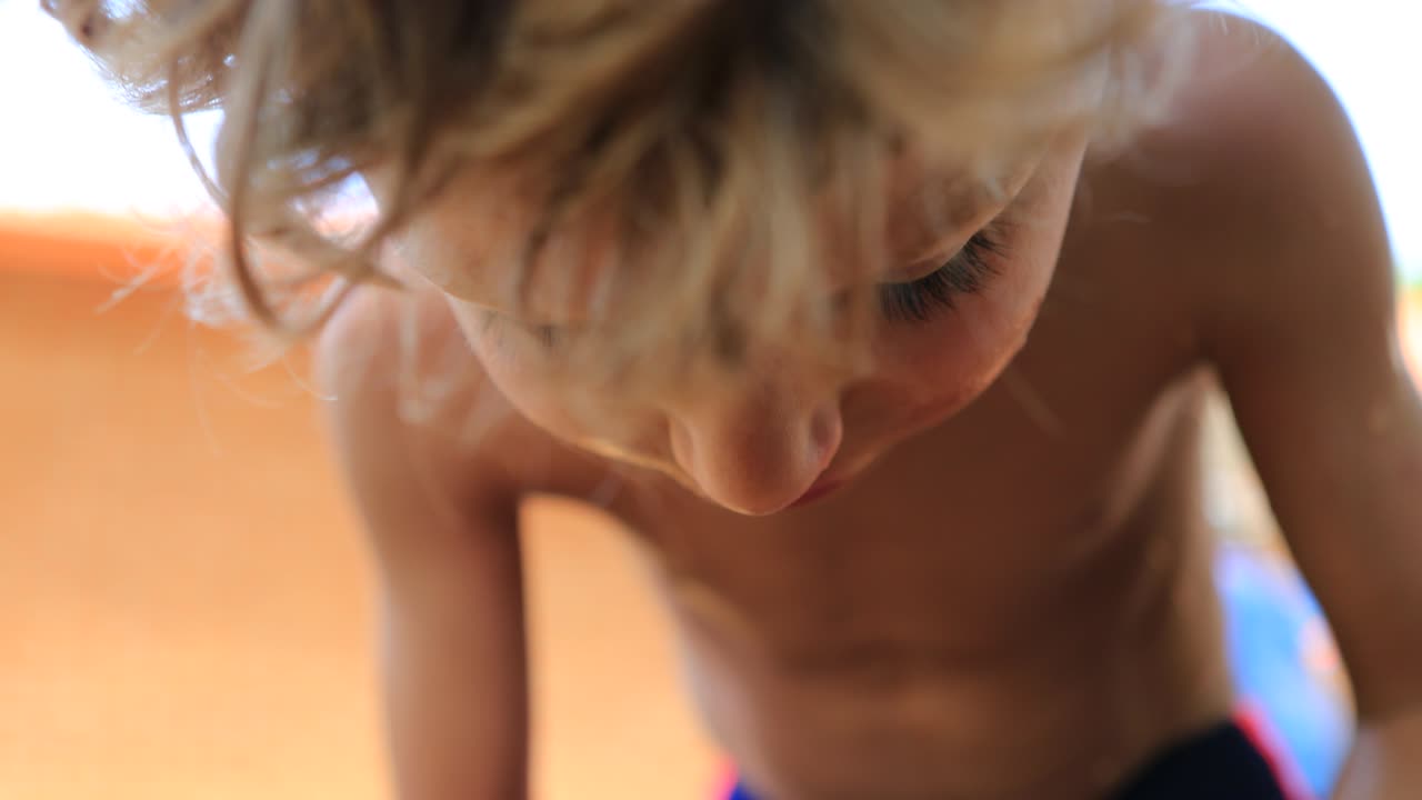 빛 아래 야외에서 오렌지를 즐기는 아이. 4k에서 건강한 과일을 먹는 어린 소년