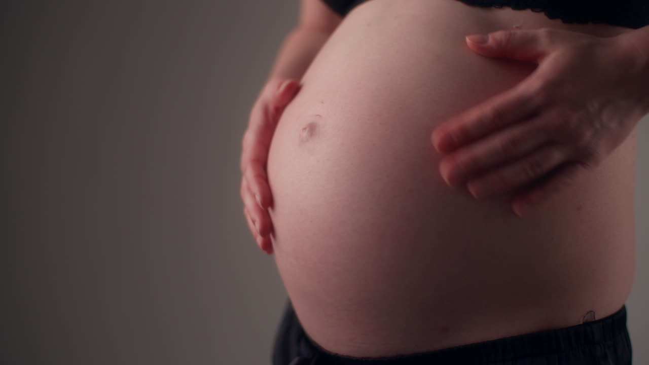 Mujer se toca el vientre con ternura durante el embarazo, esperando un bebé