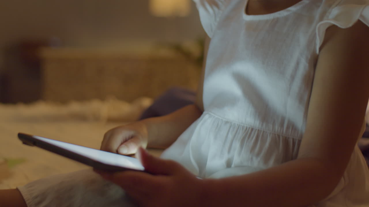 Asian Toddler Girl Playing on Digital Tablet at Home
