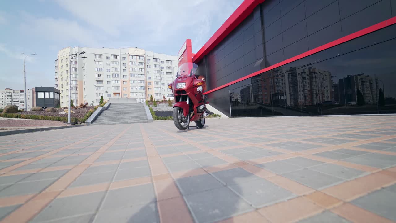 Biker girl posing on motorbike. Attractive girl in moto clothes sitting on motorcycle