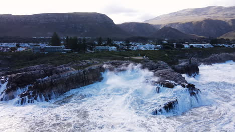 angry ocean waves crash into rocky coastline at sievers point, hermanus