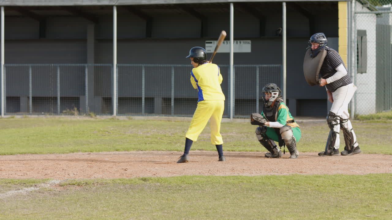 Multiracial female baseball players and male umpire, catching and hitting ball, running on pitch
