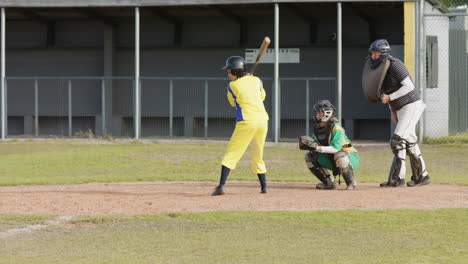 multiracial female baseball players and male umpire, catching and hitting ball, running on pitch