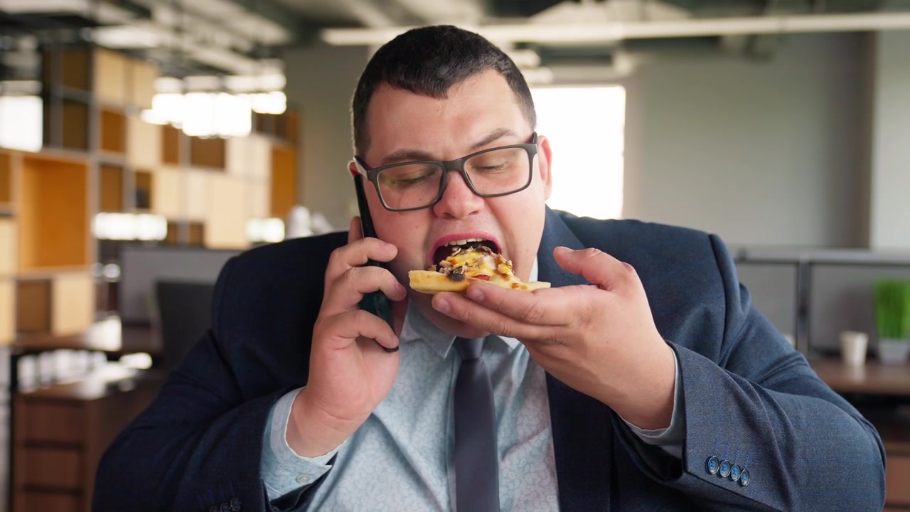 Empresário Falando ao Telefone Enquanto Come Pizza no Escritório