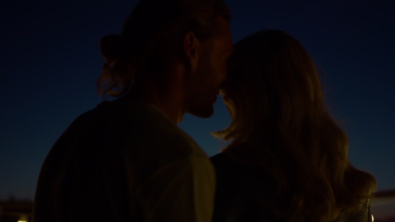 밤에 테라스에서  ⁇ 만적 인 데이트를 즐기는 커플. 남자 사랑의 말을 속삭이는.