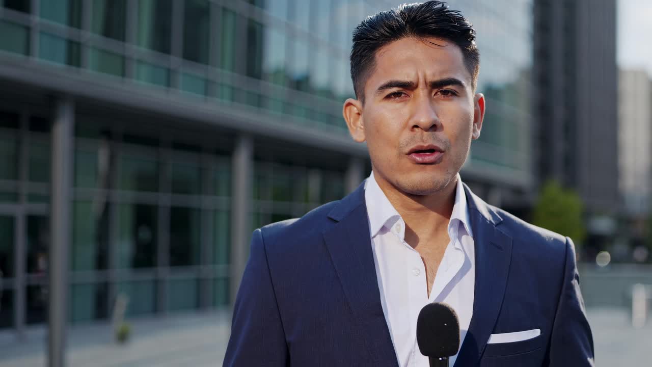 A professional man in a suit gestures during a video interview