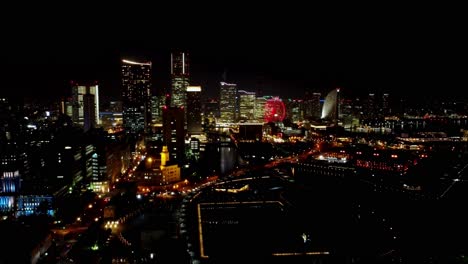 Nachtansicht-Einer-Geschäftigen-Skyline-Mit-Beleuchteten-Gebäuden-Und-Einem-Riesenrad