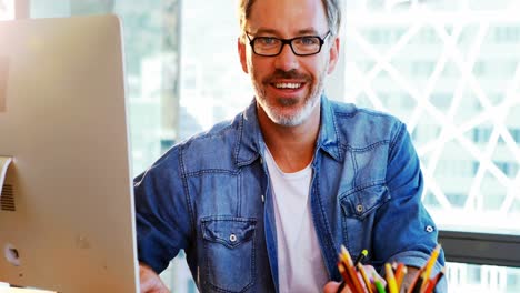 happy male graphic designer using graphic tablet at desk