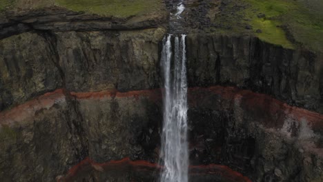 cinematic footage of idyllic waterfall crashing down into volcanic crater ravine - hengifoss waterfall in iceland