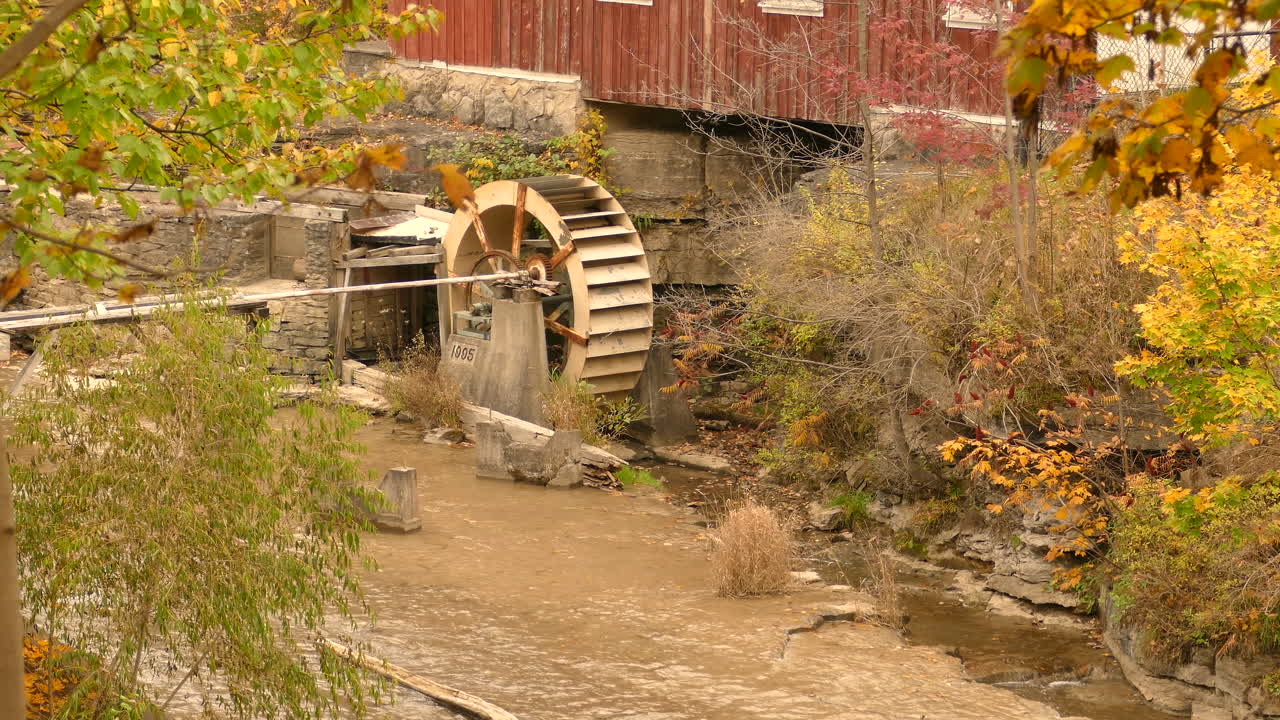 따스한 단풍과 흐르는 강물과 함께 물레방아와 폭포가 드러납니다.