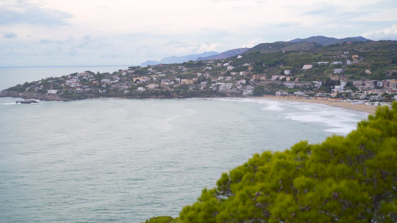 vista aérea del agua del mar del océano por la playa de arena y la península de la ciudad de gaeta con cadenas montañosas en el fondo, italia, estática