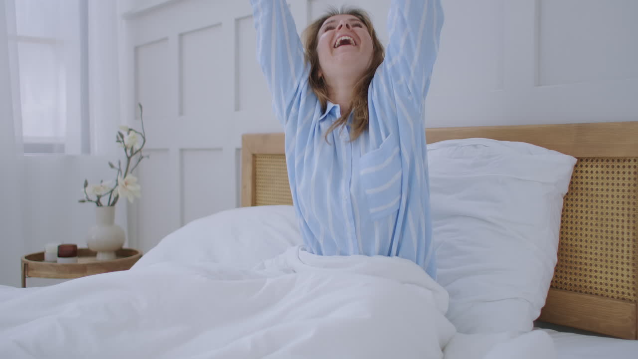 atractiva joven hermosa chateando con sus amigos mientras está sentada en su dormitorio. mujer joven acostada en la cama y sosteniendo un teléfono inteligente