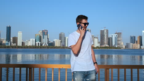 Smart-phone-man-calling-on-mobile-phone-at-in-city.-Handsome-young-business-man-talking-on-smartphone-smiling-happy-wearing-suit-jacket-outdoors.-Urban-male-professional-in-his-20s