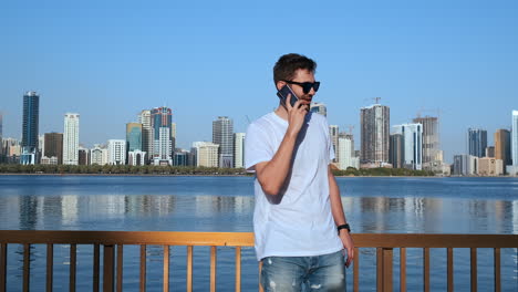 smart phone man calling on mobile phone at in city. handsome young business man talking on smartphone smiling happy wearing suit jacket outdoors. urban male professional in his 20s