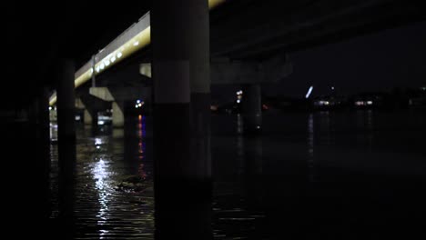 illuminated bridge reflecting on water at night