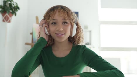 positive ethnic woman listening to music in headphones