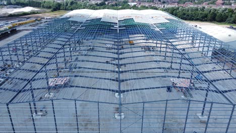 la industria de la construcción de vigas de hierro metálico marco de almacén sitio de construcción vista aérea closeup derecho lento dolly