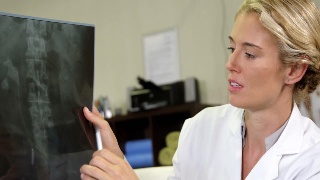 fisioterapeuta mostrando rayos x a un paciente