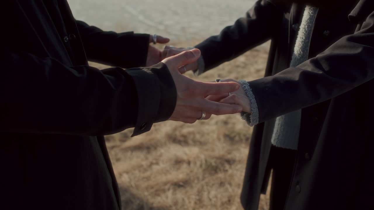 Close-Up of Romantic Couple Holding Hands Outdoors in Field