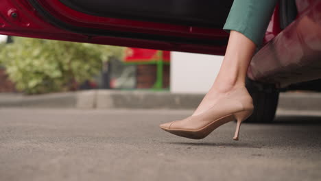 Stylish-woman-in-elegant-shoes-opens-door-getting-out-of-car