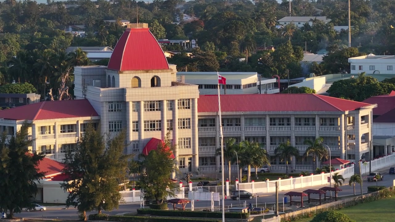 Bela imagem aérea da bandeira de Tonga e da Casa do Parlamento na capital durante o pôr do sol. Oceano Pacífico