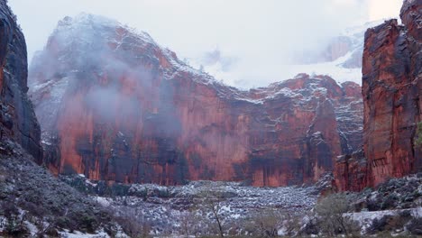 pan hacia abajo desde el cielo revelando las nubes cubrieron las montañas del parque nacional de sión en invierno