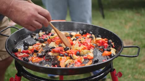 Aufnahme-Eines-Mannes,-Der-In-Einem-Garten-Eine-Traditionelle-Paella-Zubereitet