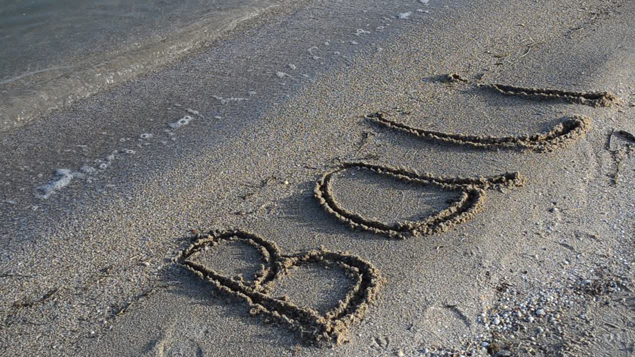 Inscription Bali on sandy beach. Inscription on sand, the beach