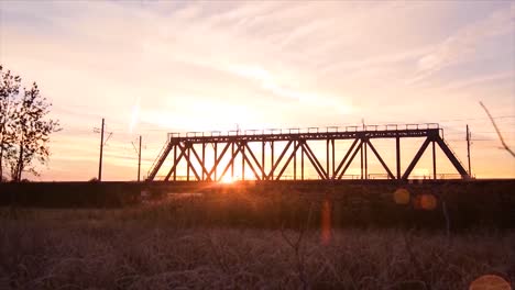 puesta de sol sobre un puente de tren